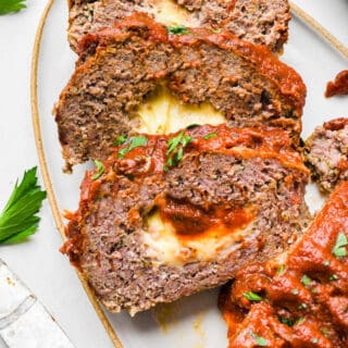 Slices of pizza meatloaf arranged on a white serving platter