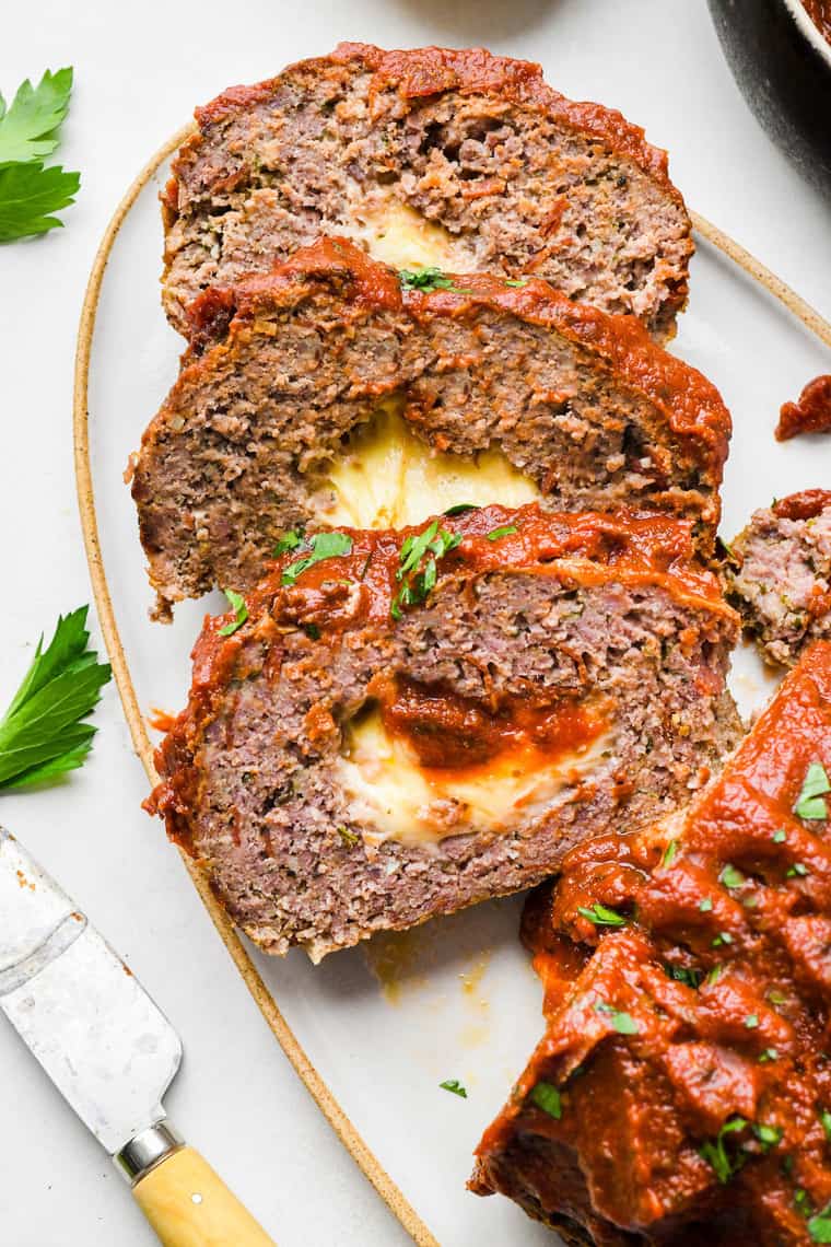 Slices of pizza meatloaf arranged on a white serving platter