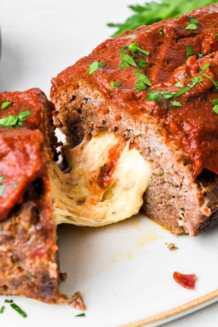 A look on the inside of a stuffed meatloaf with melted cheese oozing out