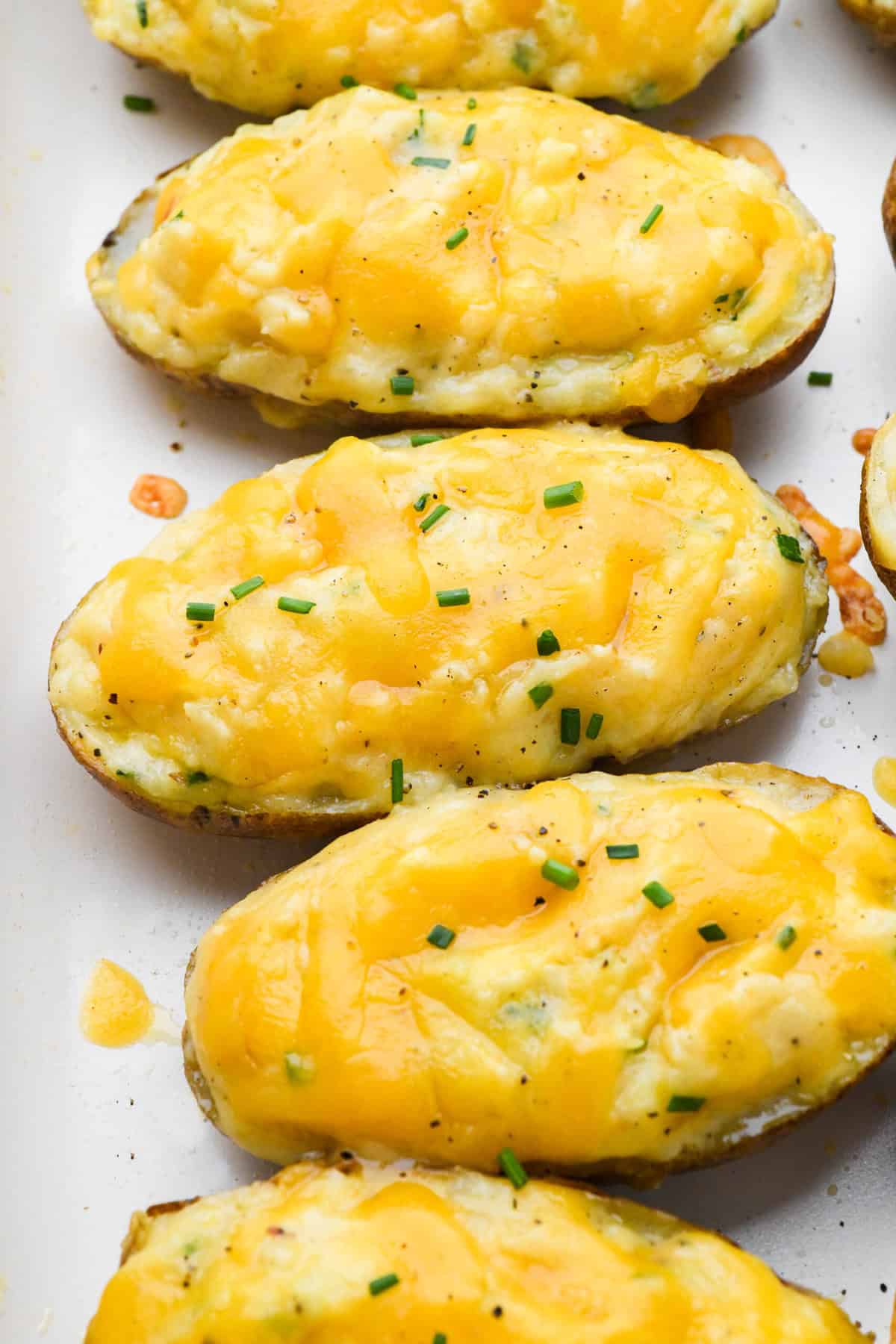 Twice baked cooked potatoes on a white serving plate