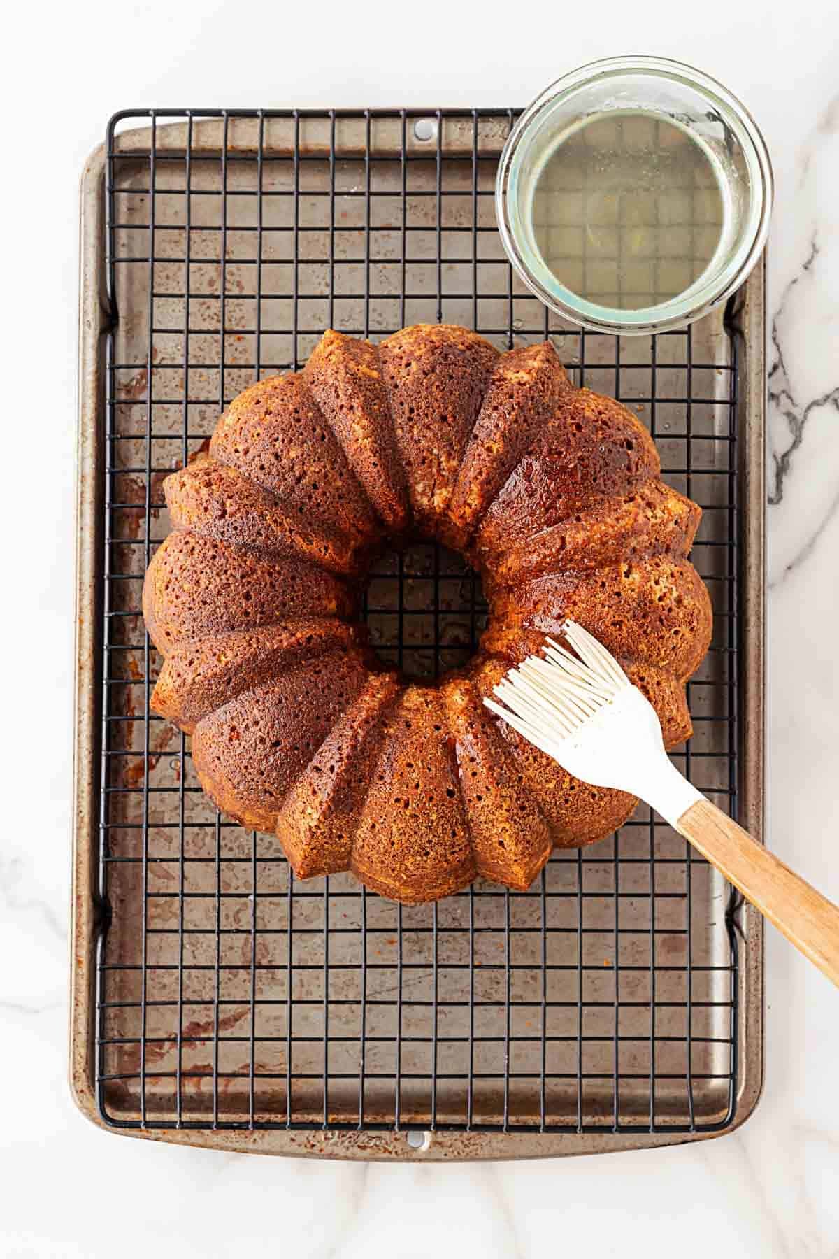 Fully baked bundt cake resting on a wire rack with syrup absorbed