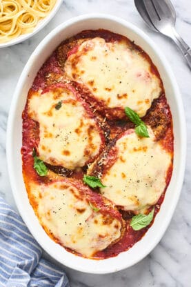 A delicious chicken parm after baking in the oven ready to serve in a white baking vessel