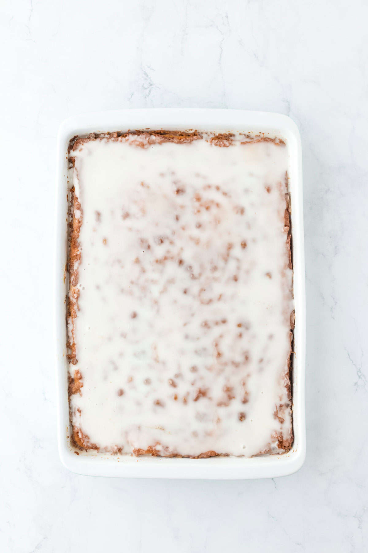 A glazed honey bun cake against a white background