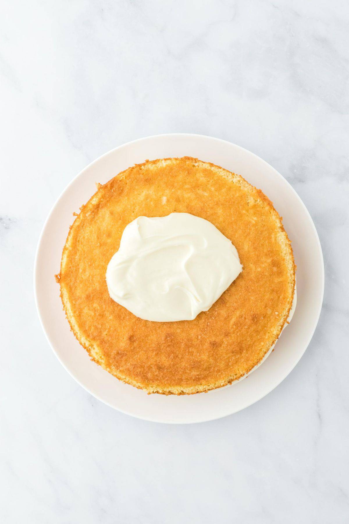 A cake with frosting partially spread on top