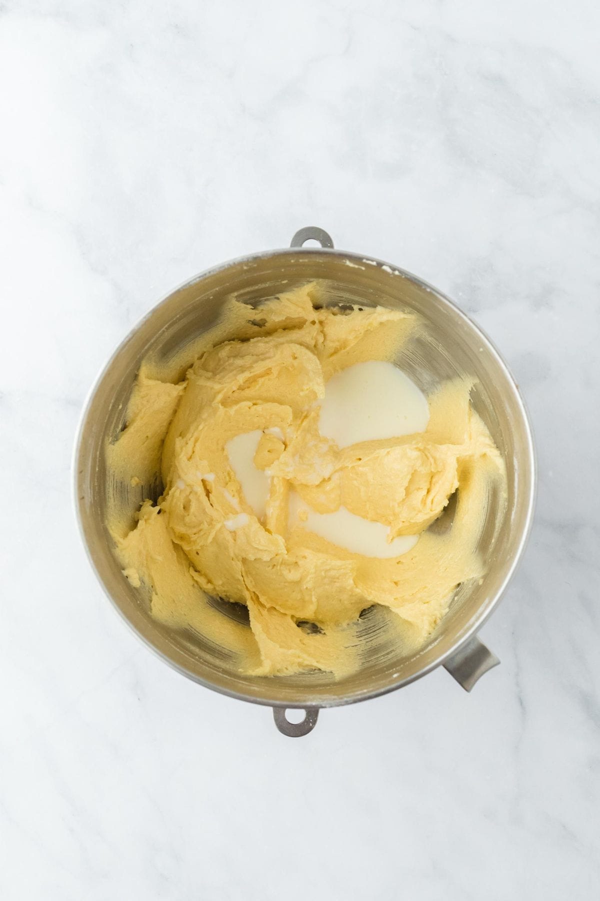 Mixing bowl with the cake batter, now with the buttermilk mixture added, ready to be combined