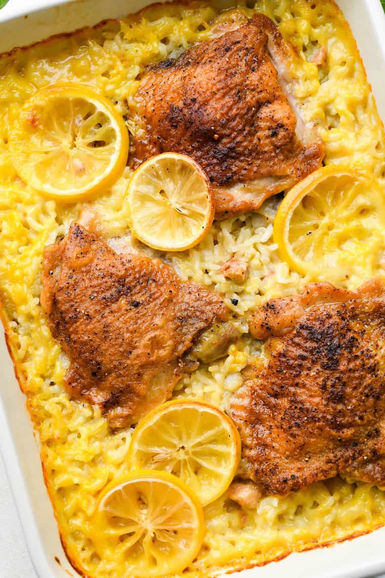 Chicken rice casserole baked in a large white casserole dish with lemon slices on top
