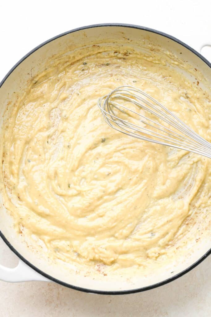 A roux being whisked in a large skillet