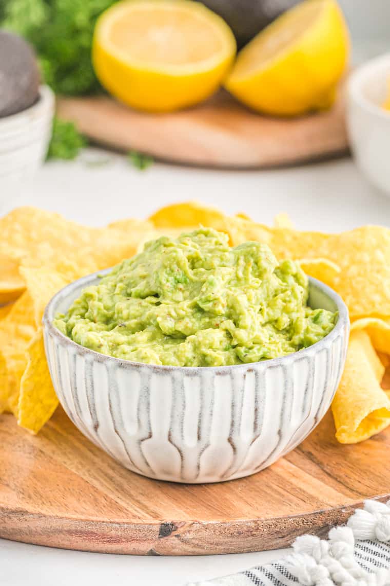 A bowl of guacamole recipe with chips on the side