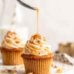 A close up of two cupcakes with one carrot cake cupcake having caramel poured on top
