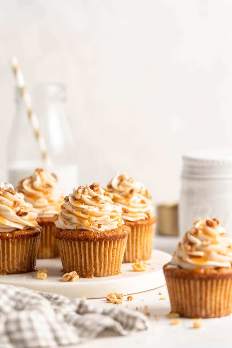 Several carrot cake cupcakes ready to serve against a white background