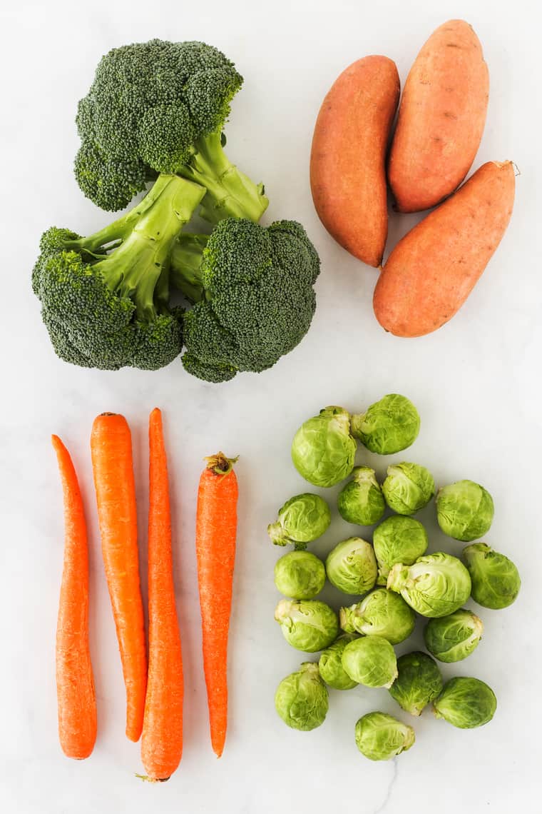 An overhead photo of broccoli, sweet potato, carrots and brussels sprout