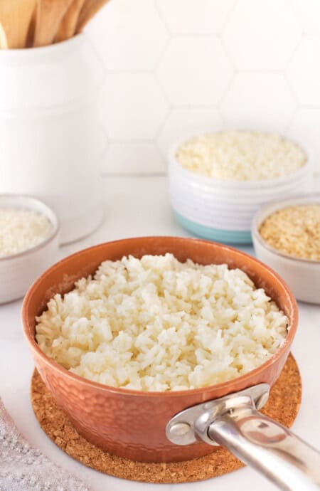 A pot of white rice against a white background