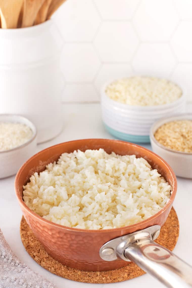 A pot of white rice against a white background