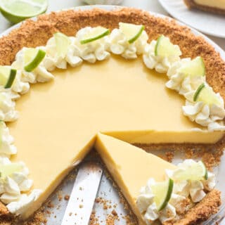 A close up of a key lime pie with slices removed