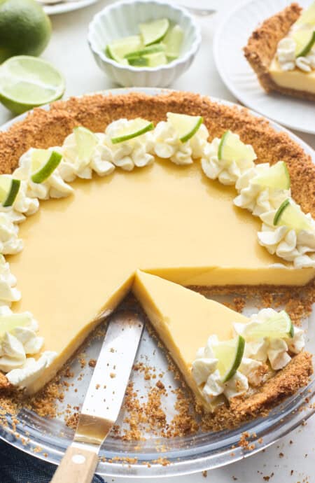 A close up of a key lime pie with slices removed
