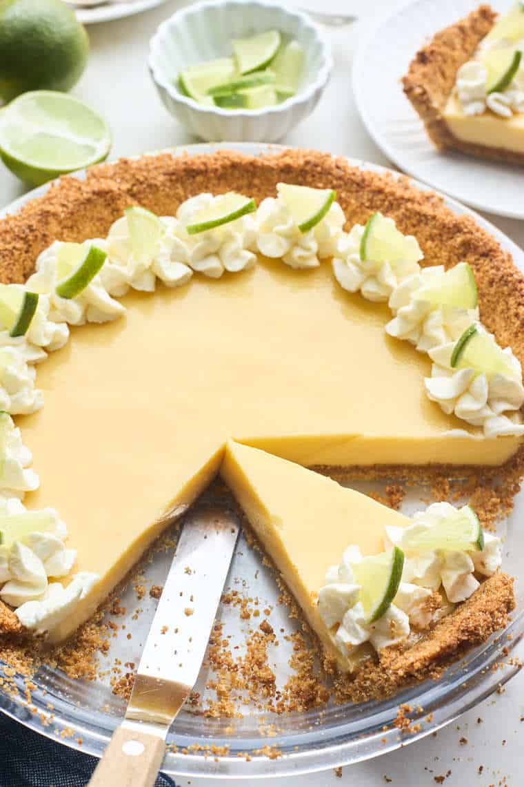 A close up of a key lime pie with slices removed