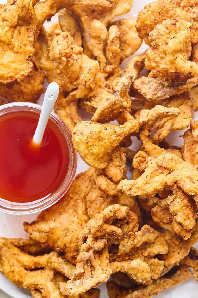 A close up of fried oyster mushrooms with a spicy maple syrup