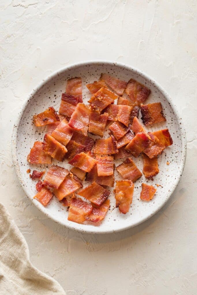 Cooked bacon chopped on a white plate