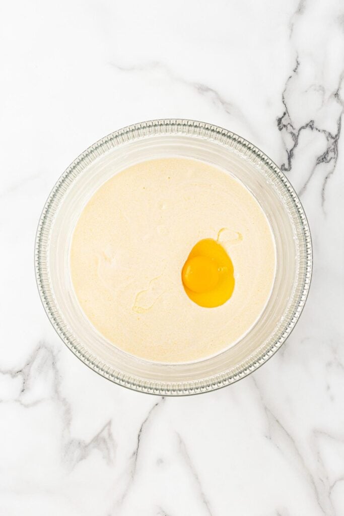 Eggs being added to funfetti cake batter