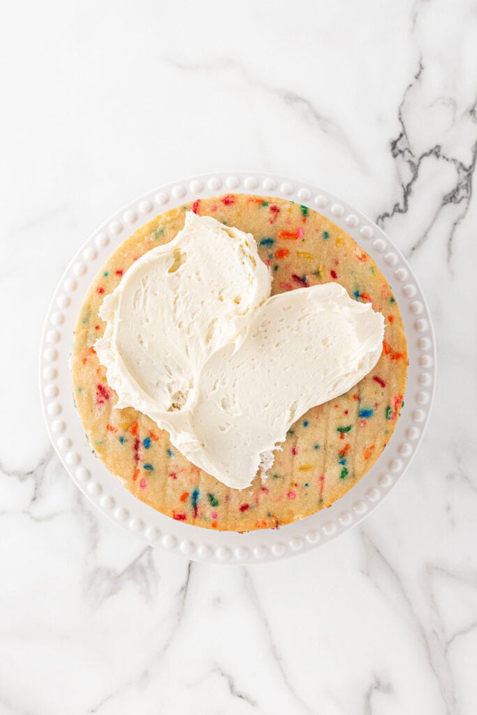 Buttercream spread on funfetti cake layer to frost