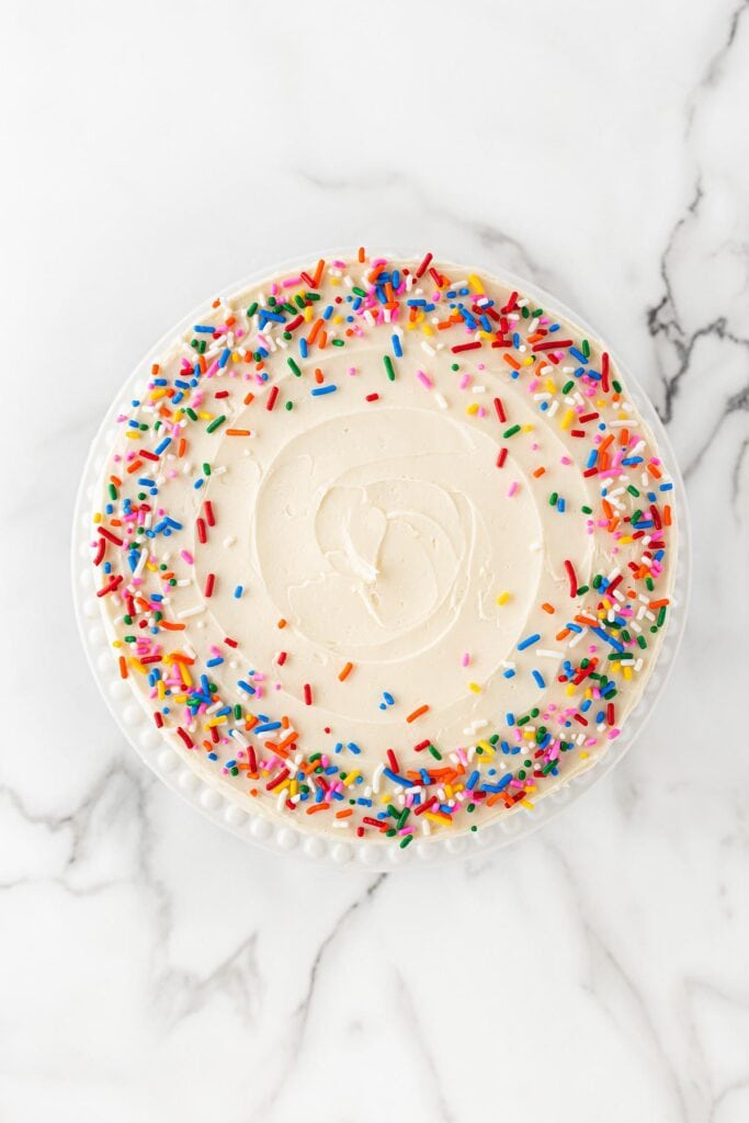 Sprinkles added to top of funfetti cake after decorating
