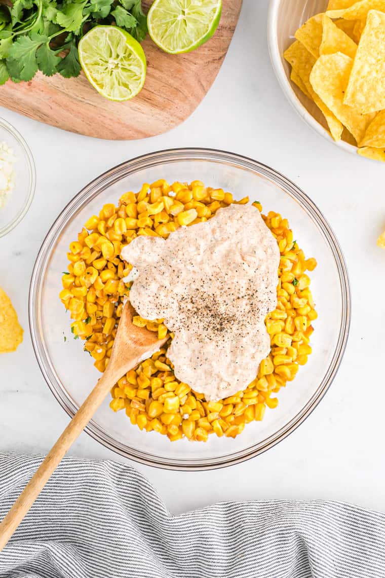 A sour cream mix being combined with corn kernels