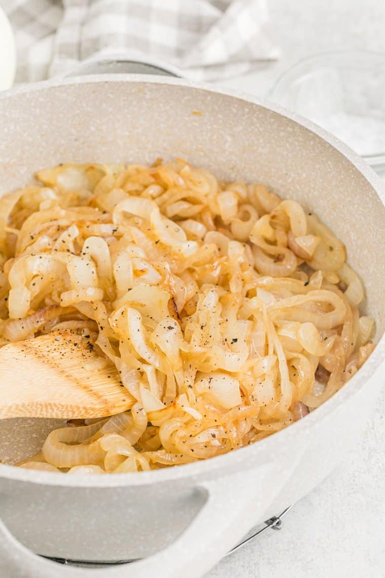 Sauteed onions in a skillet being stirred