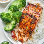 A honey garlic salmon filet being eaten with white rice and broccoli