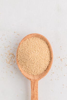 Active yeast on a spoon against a white background