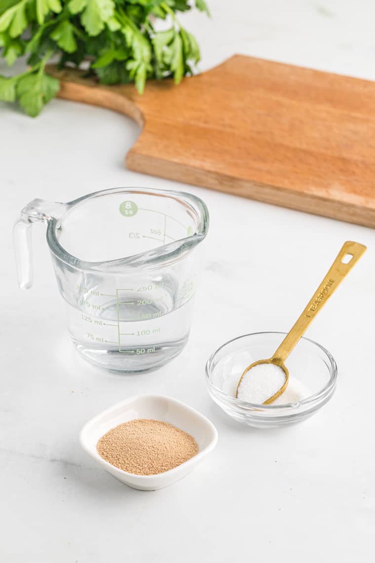 Water in a measuring cup, yeast and salt