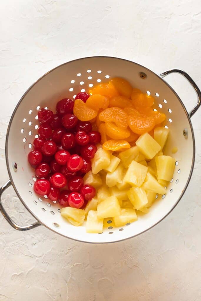Cherries, mandarin oranges and pineapple in a colinder