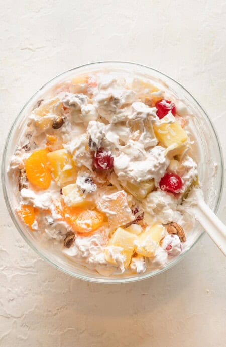 A close up of southern ambrosia salad in a clear bowl before serving