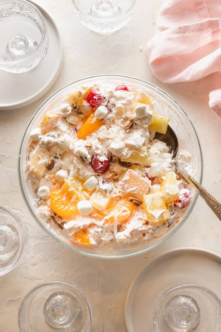 An ambrosia salad recipe with a spoon ready to serve