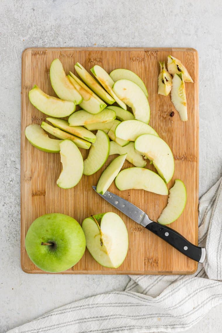 Slices of granny smith apples on a wooden board