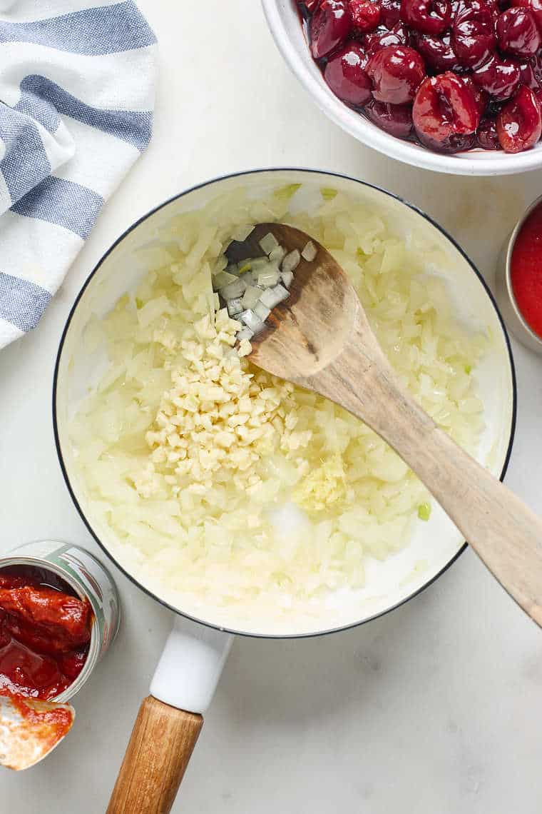 Onions and garlic being cooked in a skillet