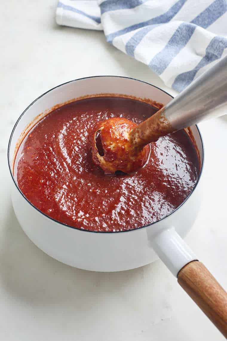 Cherry bbq sauce being blended together with an immersion blender