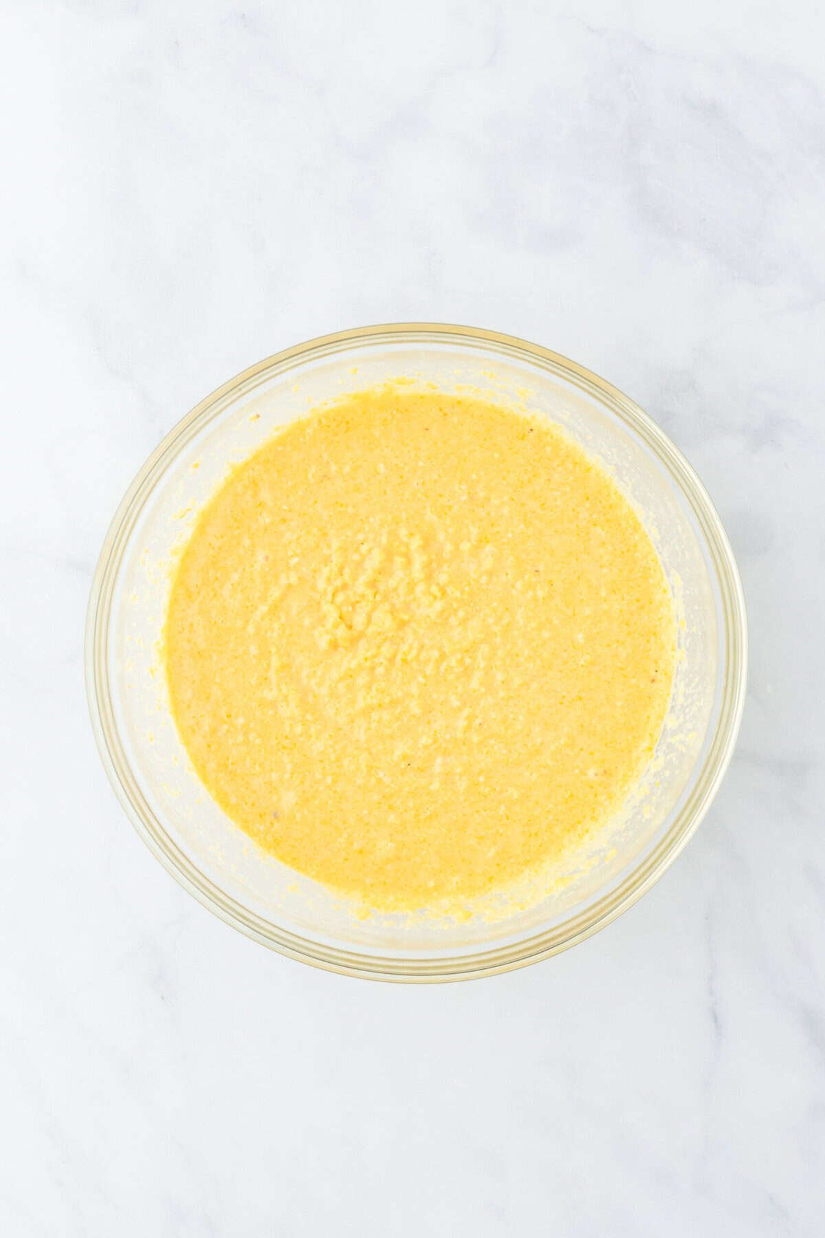 A smooth corn pone mixture in a clear bowl