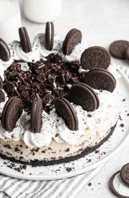 A close up of cookies and cream cheesecake with cookies on top along with whipped cream