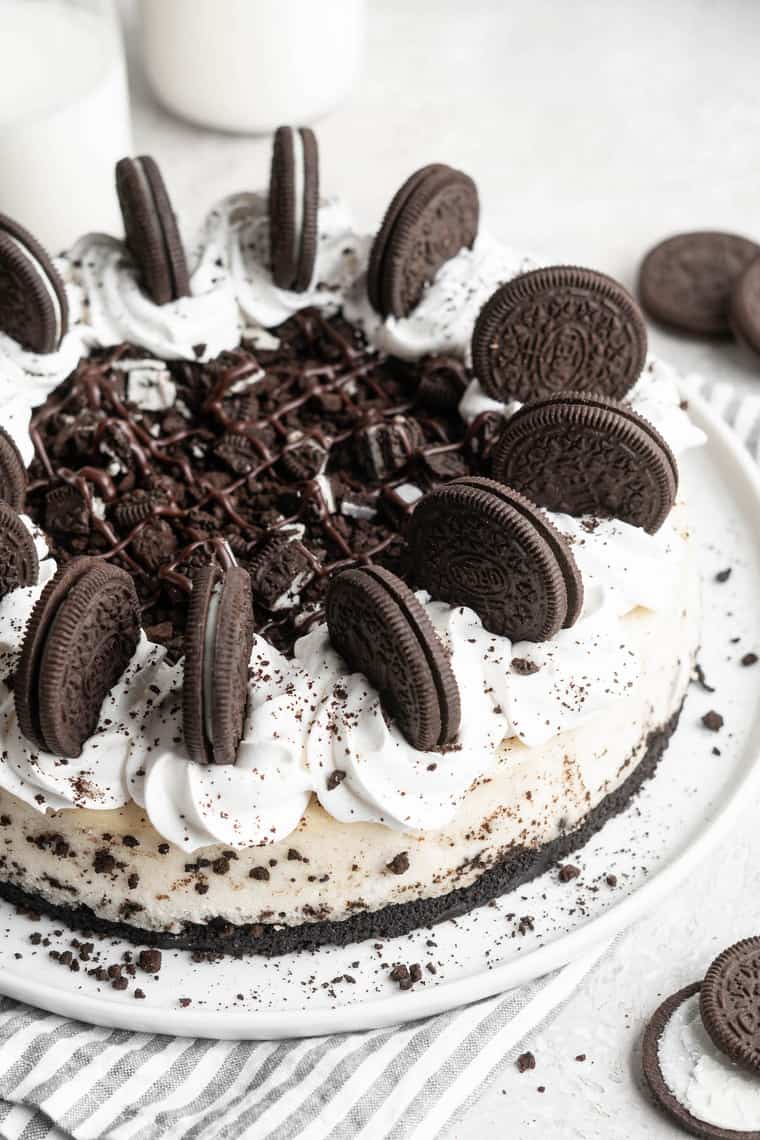 A close up of cookies and cream cheesecake with cookies on top along with whipped cream