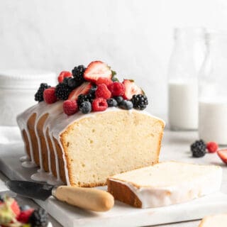 A beautiful sour cream cake with berries and white icing on top ready to serve