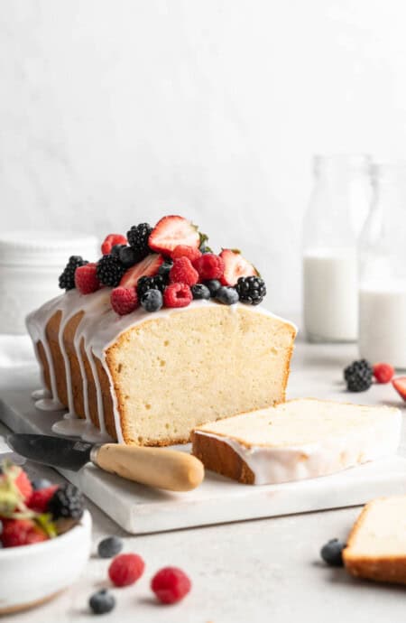 A beautiful sour cream cake with berries and white icing on top ready to serve