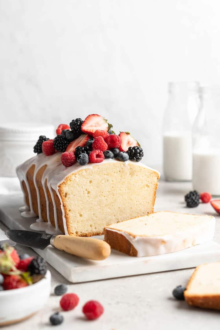 A beautiful sour cream cake with berries and white icing on top ready to serve