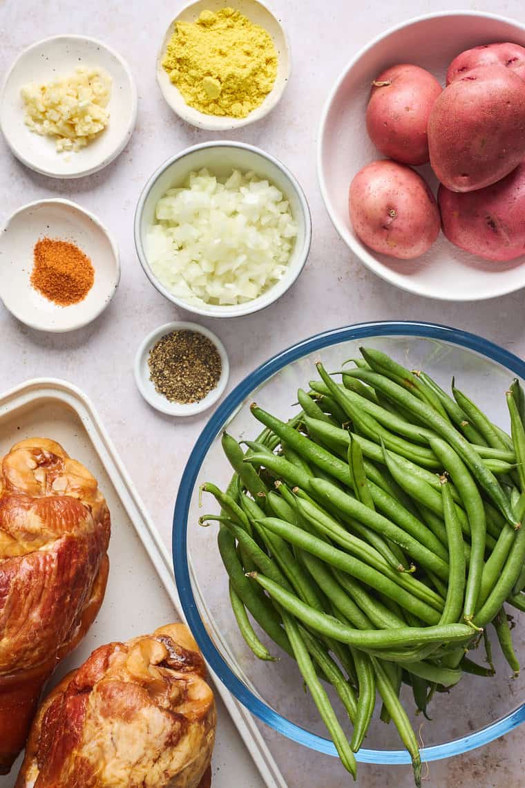 Green beans, smoked turkey, potatoes and spices on a white background