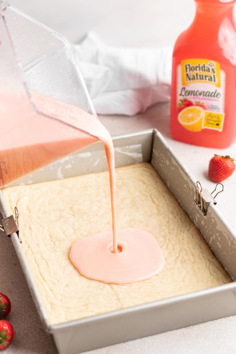 Strawberry lemon filling being poured over a shortbread crust