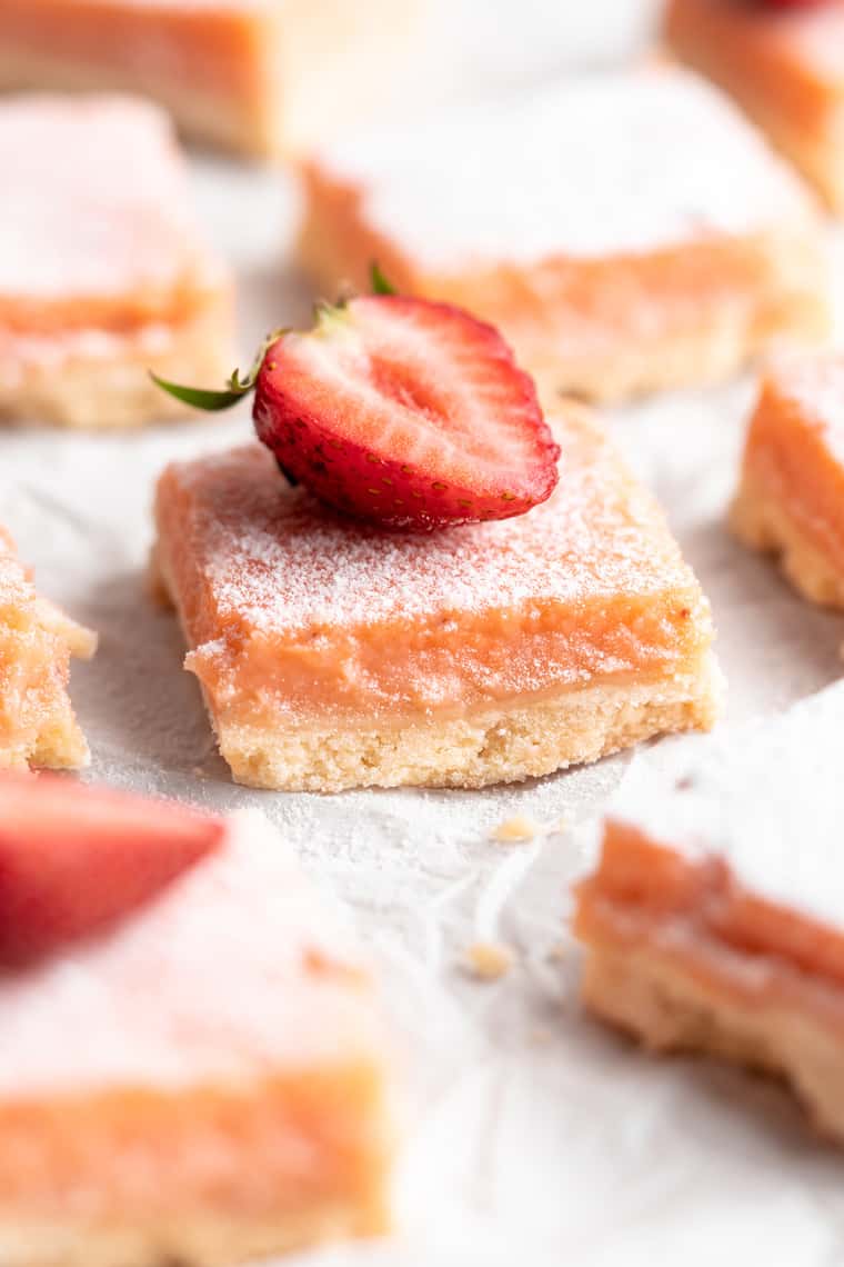 A close up of a strawberry lemon bar with a strawberry slice on top