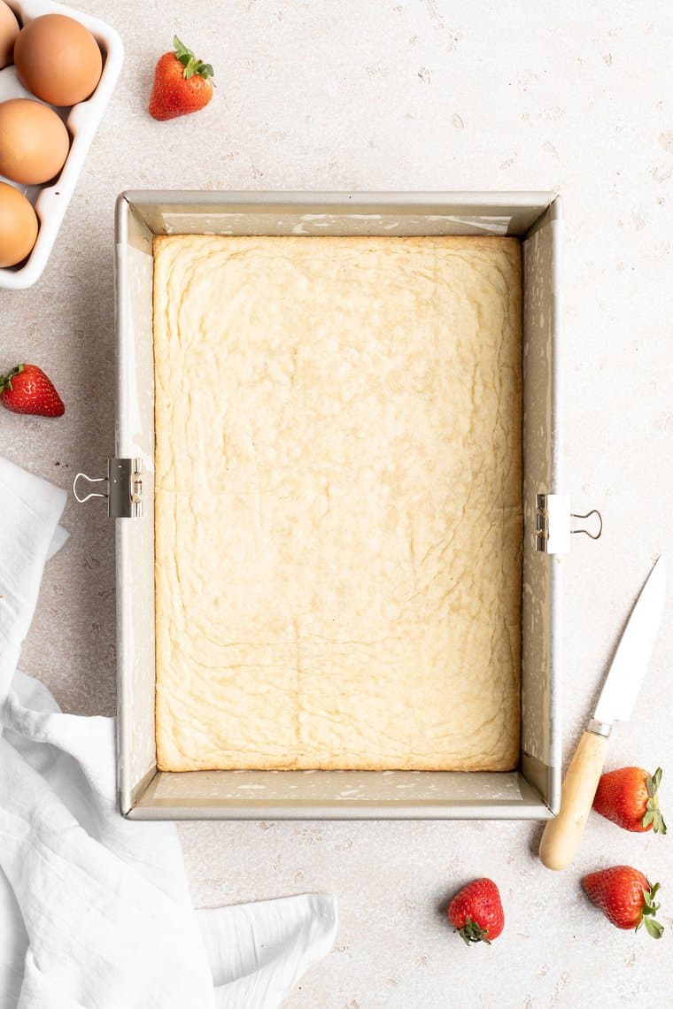 Shortbread crust in a large baking pan after coming out of the oven