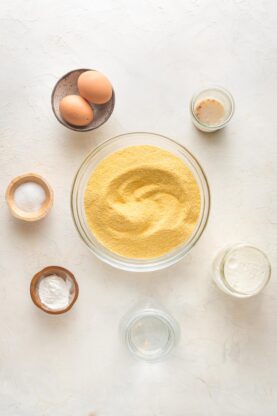 Cornmeal, eggs, sugar, salt and ingredients in clear bowls