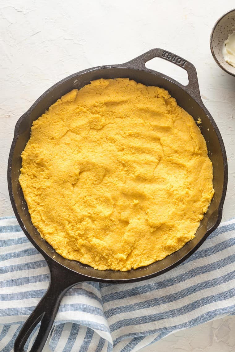 Boiled cornmeal and ingredients patted into a cast iron skillet