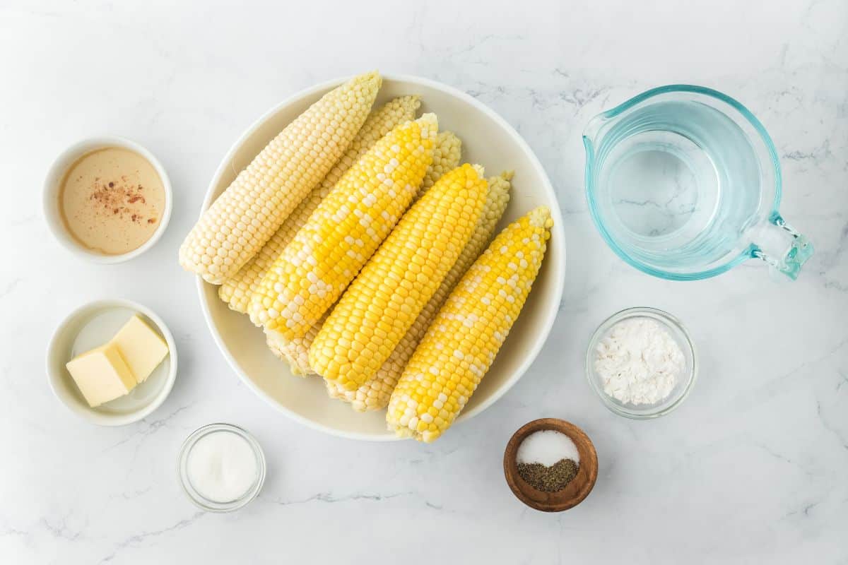 Ingredients to make fried corn before preparing in white bowls on a white background.