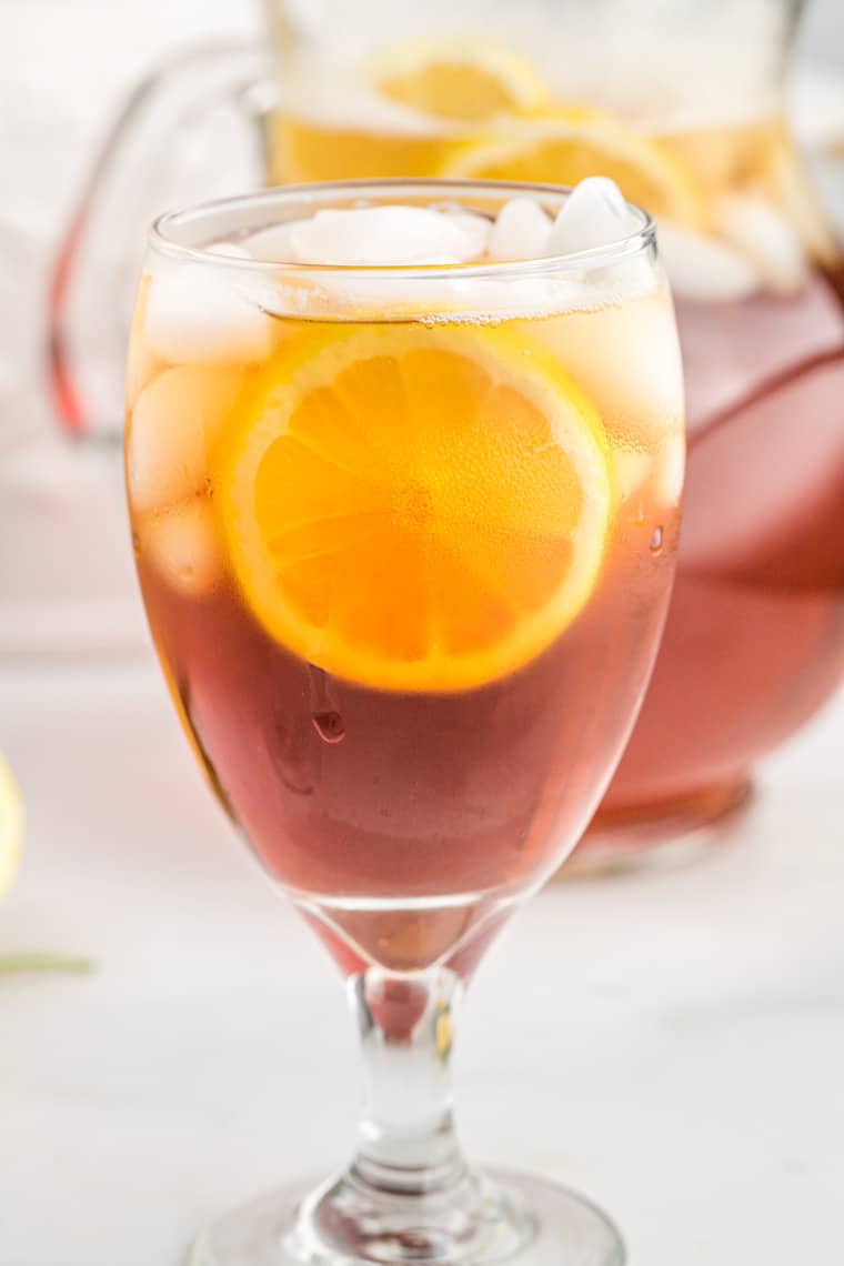 A close up glass of iced sweet tea with lemon ready to serve.
